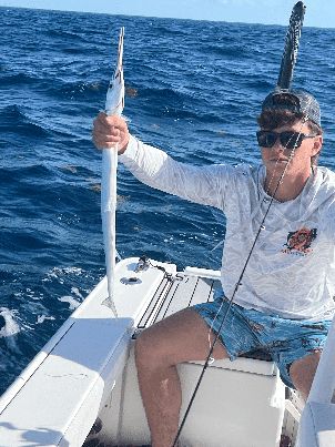 Angler fighting a fish with a bent rod on the deck