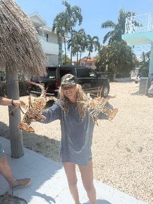 Angler holding up a big catch on a Key Largo beach